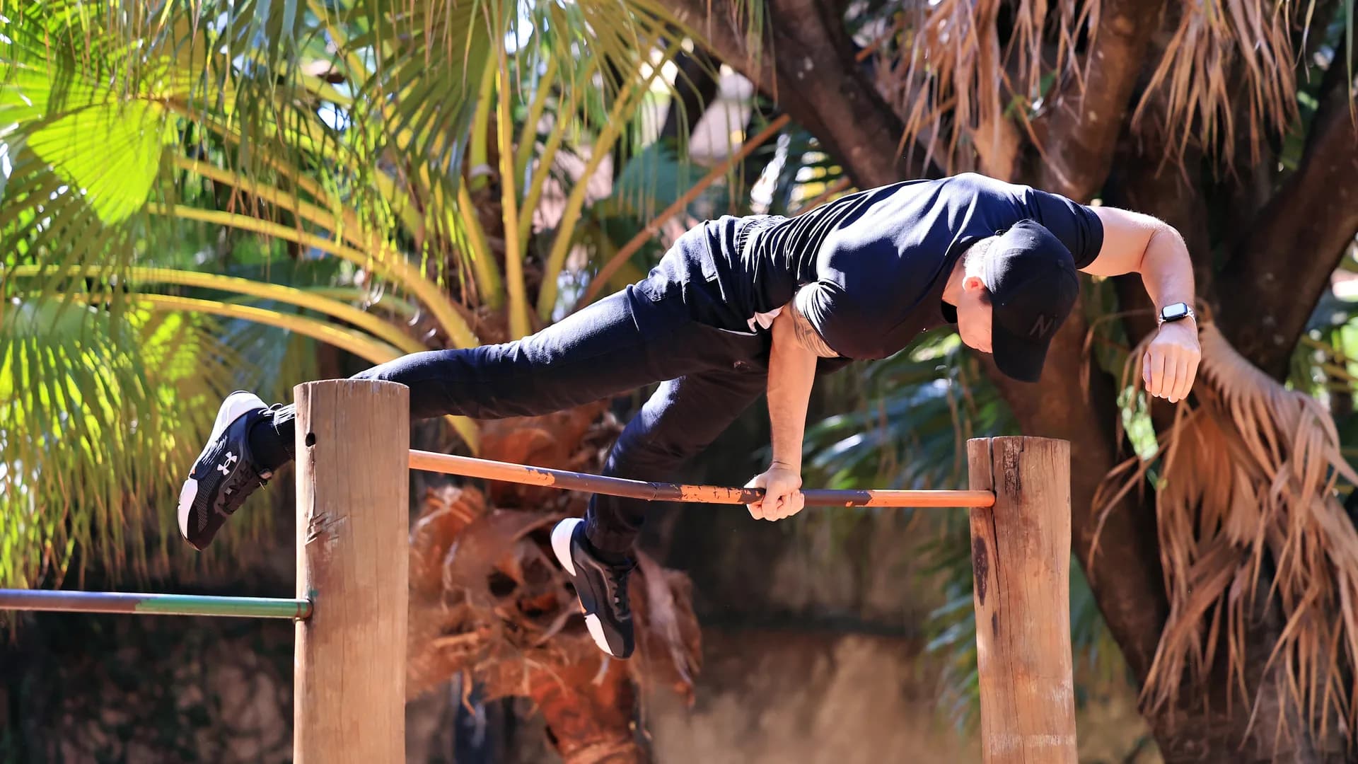 Gabriel em elbow lever com um braço sobre a barra, corpo estendido na horizontal